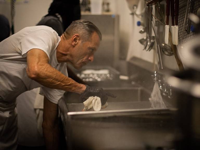 Jorge leaning over a sink