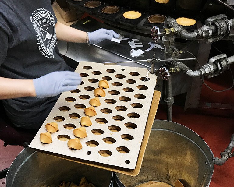 person working on a machine that makes Chinese cookies